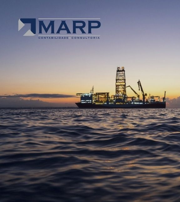 Navio-sonda industrial iluminado ancorado no mar ao entardecer, céu em degradê azul e laranja, reflexos dourados na água, logotipo da MARP Contabilidade Consultoria sobreposto, fotografia realista corporativa